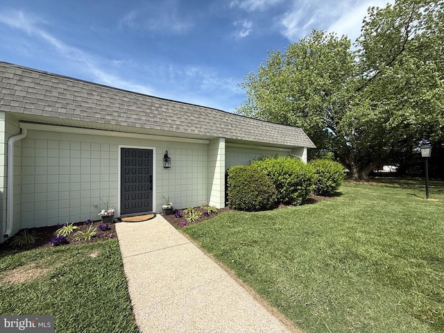 195 S Dr Unit E6, Kilmarnock, VA 22482 - view of exterior entry featuring a shingled roof, a lawn, and mansard roof
