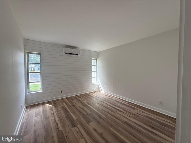 195 S Dr Unit E6, Kilmarnock, VA 22482 - unfurnished room featuring a wall mounted AC, baseboards, wood finished floors, and wooden walls