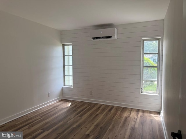 195 S Dr Unit E6, Kilmarnock, VA 22482 - unfurnished room featuring a wall unit AC, baseboards, dark wood-style flooring, and wooden walls