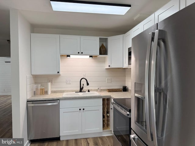 195 S Dr Unit E6, Kilmarnock, VA 22482 - kitchen featuring stainless steel appliances, a sink, white cabinets, wood finished floors, and light stone counters
