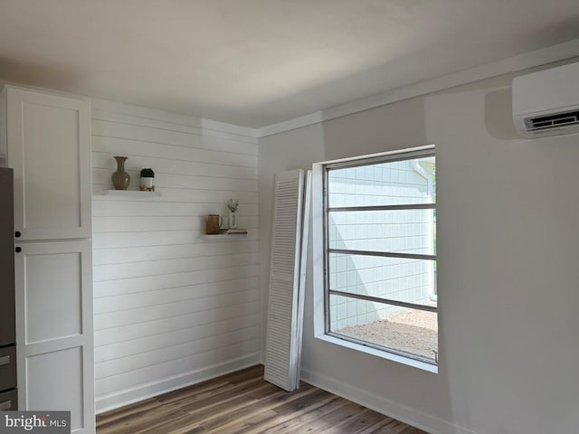 195 S Dr Unit E6, Kilmarnock, VA 22482 - interior space featuring wood finished floors, an AC wall unit, and baseboards