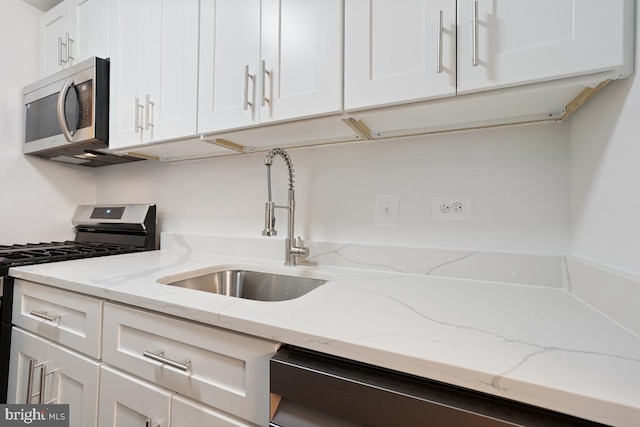1900 Lyttonsville Rd Unit 216, Silver Spring, MD 20910 - kitchen with stainless steel appliances, a sink, white cabinetry, and light stone countertops
