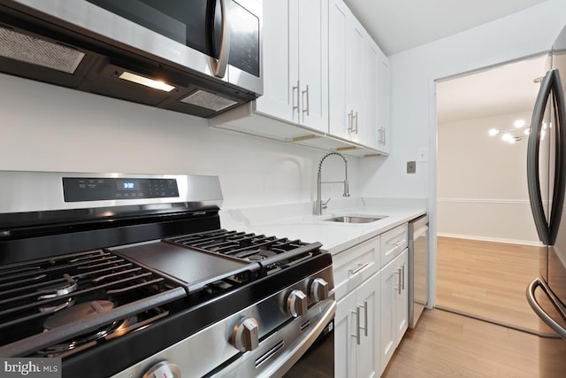 1900 Lyttonsville Rd Unit 216, Silver Spring, MD 20910 - kitchen featuring stainless steel appliances, a sink, white cabinets, light wood finished floors, and baseboards