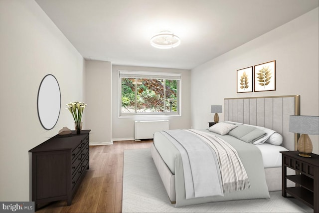 1900 Lyttonsville Rd Unit 216, Silver Spring, MD 20910 - bedroom featuring radiator heating unit, wood finished floors, and baseboards