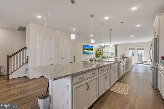 kitchen featuring a sink, stainless steel appliances, dark wood-style flooring, a large island, and recessed lighting