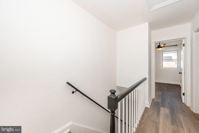 hallway with an upstairs landing, wood finished floors, and baseboards