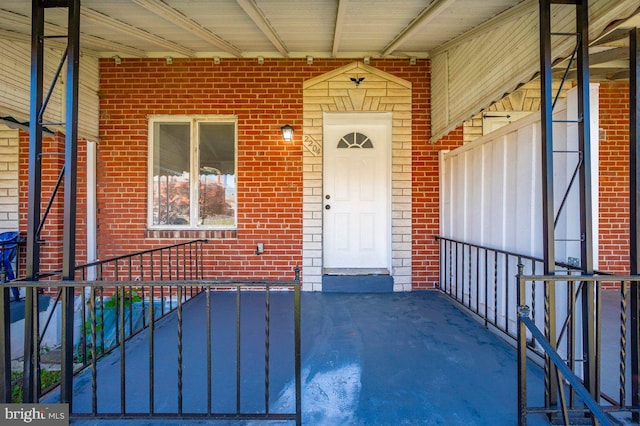 view of exterior entry featuring brick siding
