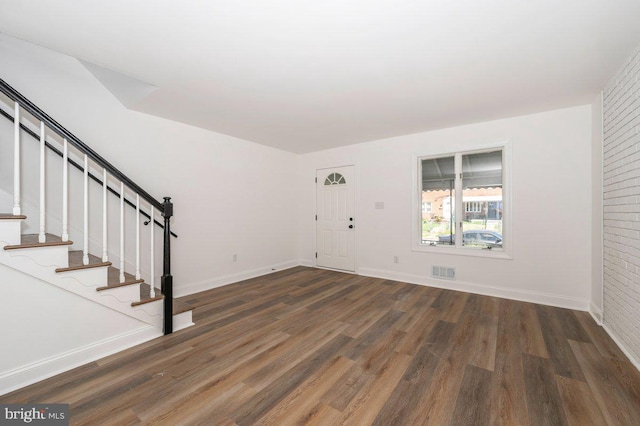 foyer entrance with wood finished floors, stairs, and baseboards