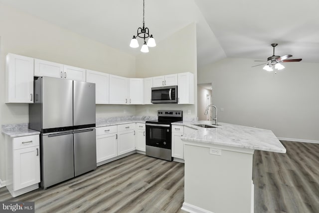 kitchen with appliances with stainless steel finishes, a sink, a peninsula, light wood-style flooring, and white cabinets