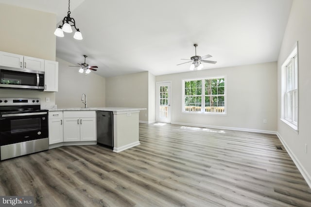 kitchen featuring stainless steel appliances, a ceiling fan, open floor plan, a peninsula, and lofted ceiling