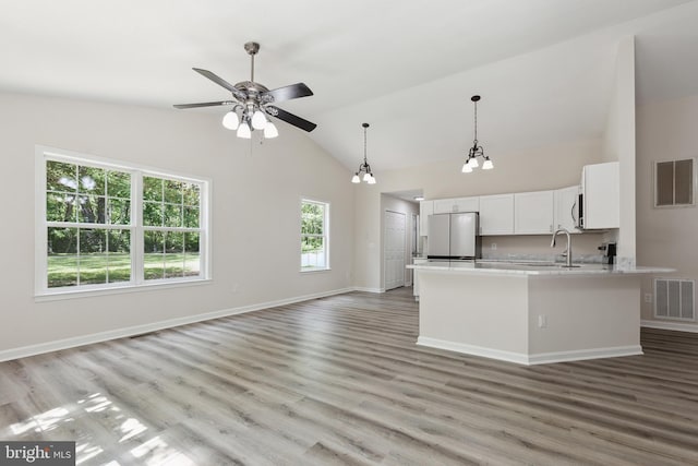 kitchen with freestanding refrigerator, light countertops, vaulted ceiling, a ceiling fan, and hanging light fixtures