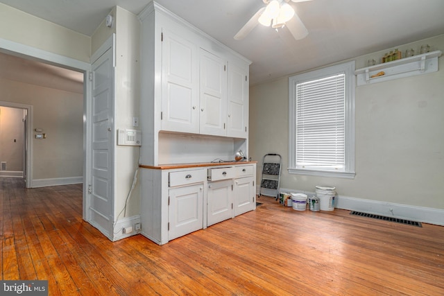 116 Price St, West Chester, PA 19382 - kitchen featuring white cabinets, light wood-style floors, a ceiling fan, baseboards, and heating unit