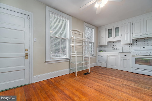 116 Price St, West Chester, PA 19382 - kitchen with white gas stove, under cabinet range hood, baseboards, white cabinets, and a ceiling fan
