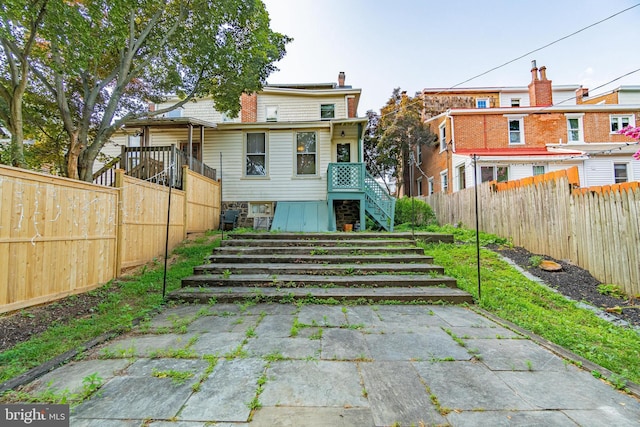 116 Price St, West Chester, PA 19382 - back of property with a fenced backyard, stairs, and a chimney