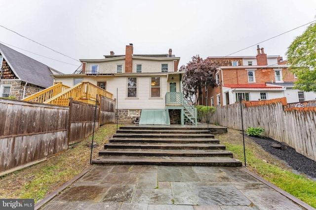 116 Price St, West Chester, PA 19382 - back of property featuring stairs, a fenced backyard, and a chimney