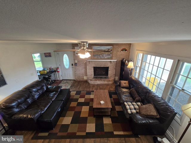 33 Middlebury Ln, Willingboro, NJ 08046 - living room featuring wood finished floors, a textured ceiling, a brick fireplace, a ceiling fan, and ornamental molding