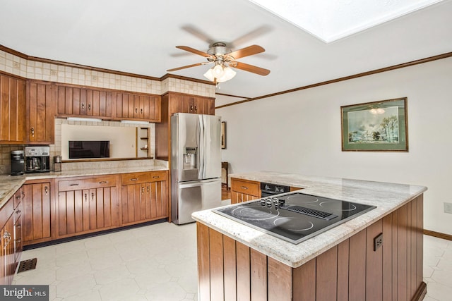 1021 Carson Dr, Huntingtown, MD 20639 - kitchen with stainless steel fridge with ice dispenser, black electric stovetop, brown cabinets, light flooring, and a ceiling fan