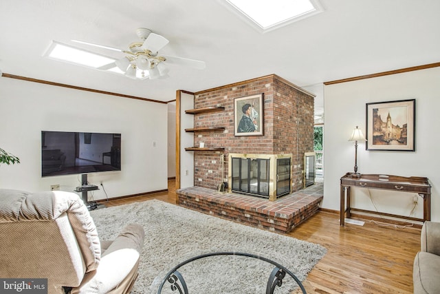 1021 Carson Dr, Huntingtown, MD 20639 - living area featuring wood finished floors, crown molding, a brick fireplace, and ceiling fan