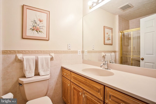1021 Carson Dr, Huntingtown, MD 20639 - full bath featuring vanity, a shower stall, tile walls, wainscoting, and a textured ceiling