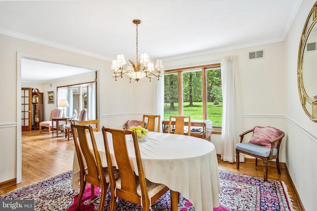 1021 Carson Dr, Huntingtown, MD 20639 - dining space with a chandelier, crown molding, and light wood-style floors