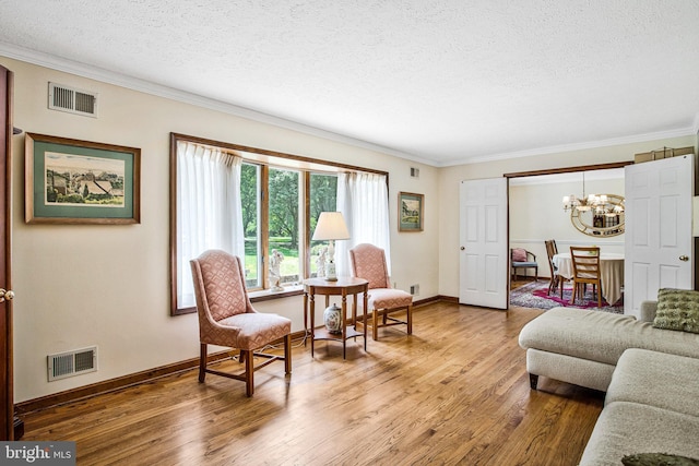 1021 Carson Dr, Huntingtown, MD 20639 - living area with a chandelier, a textured ceiling, ornamental molding, and wood finished floors