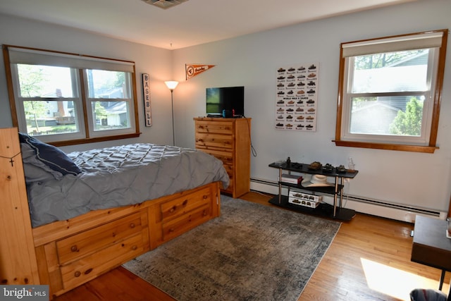 194 Irene Ave, Pasadena, MD 21122 - bedroom featuring multiple windows, wood finished floors, and a baseboard radiator