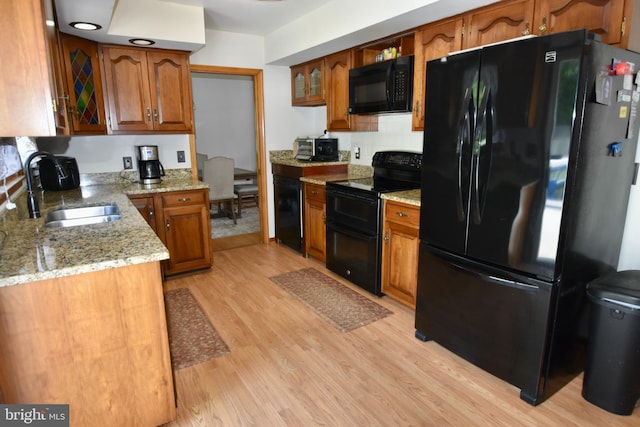 194 Irene Ave, Pasadena, MD 21122 - kitchen featuring black appliances, a sink, brown cabinets, light wood-style flooring, and light stone counters