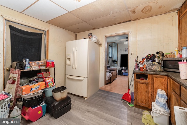 346 W Burkhart Ave, Chambersburg, PA 17201 - kitchen with white fridge with ice dispenser, stainless steel microwave, brown cabinets, a paneled ceiling, and light wood-style floors