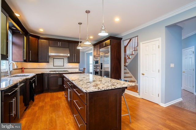 4 Bernadette Cir, Monmouth Junction, NJ 08852 - kitchen with a sink, under cabinet range hood, appliances with stainless steel finishes, ornamental molding, and a breakfast bar