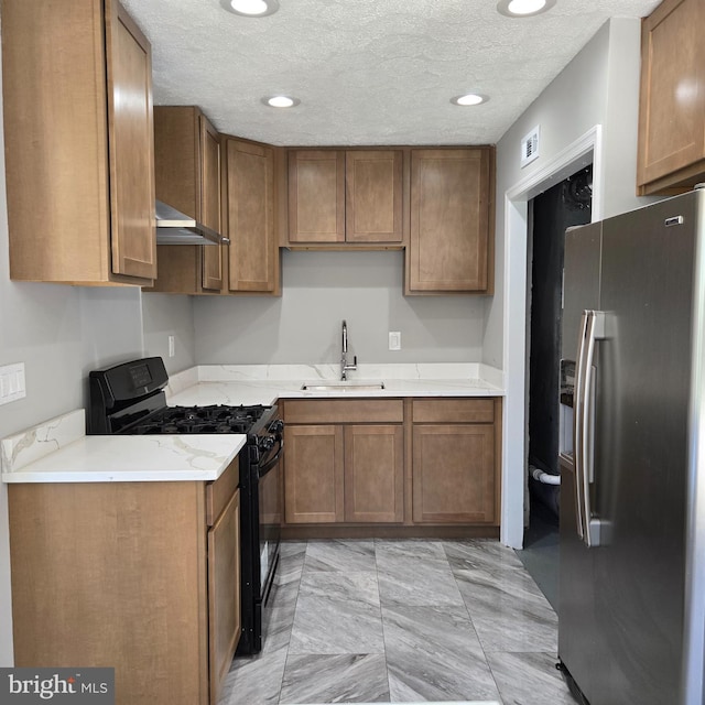 9711 Dilston Rd, Silver Spring, MD 20903 - kitchen featuring stainless steel refrigerator with ice dispenser, gas stove, a sink, brown cabinetry, and a textured ceiling