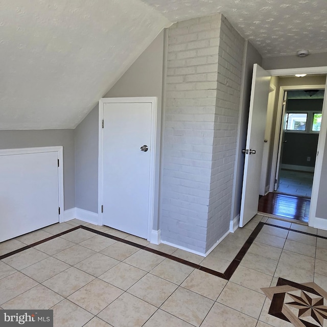 9711 Dilston Rd, Silver Spring, MD 20903 - bonus room with inlaid floor details, light tile patterned floors, baseboards, vaulted ceiling, and a textured ceiling