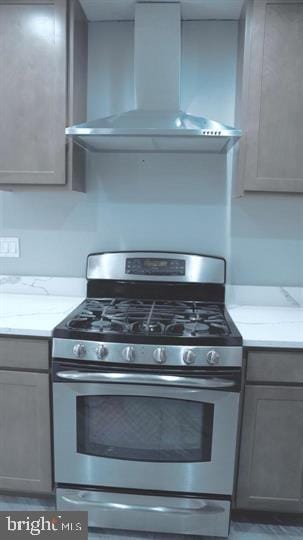 9711 Dilston Rd, Silver Spring, MD 20903 - kitchen with gas range, wall chimney exhaust hood, gray cabinetry, and light stone countertops
