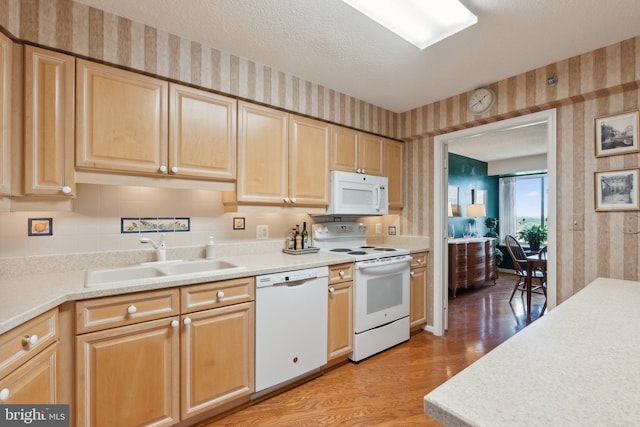 19385 Cypress Ridge Ter Unit 814, Leesburg, VA 20176 - kitchen with wallpapered walls, white appliances, a sink, light wood-style flooring, and light countertops