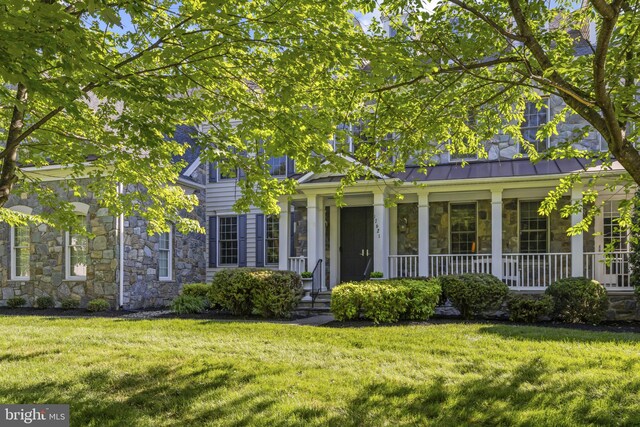 17621 Auburn Village Dr, Sandy Spring, MD 20860 - view of front of property featuring stone siding, a front yard, and covered porch