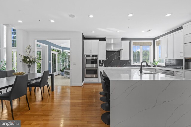 17621 Auburn Village Dr, Sandy Spring, MD 20860 - kitchen with stainless steel appliances, wall chimney exhaust hood, a sink, tasteful backsplash, and recessed lighting