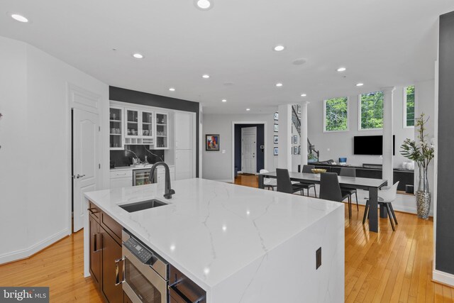 17621 Auburn Village Dr, Sandy Spring, MD 20860 - kitchen with a sink, light wood-type flooring, recessed lighting, stainless steel microwave, and glass insert cabinets