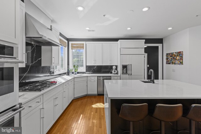 17621 Auburn Village Dr, Sandy Spring, MD 20860 - kitchen with stainless steel appliances, a kitchen bar, tasteful backsplash, recessed lighting, and white cabinetry
