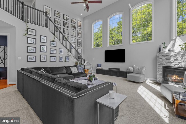 17621 Auburn Village Dr, Sandy Spring, MD 20860 - living area featuring a high ceiling, ceiling fan, a glass covered fireplace, carpet floors, and stairs