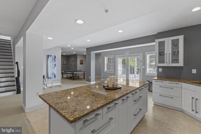 17621 Auburn Village Dr, Sandy Spring, MD 20860 - kitchen with white cabinetry, light stone counters, glass insert cabinets, recessed lighting, and a center island
