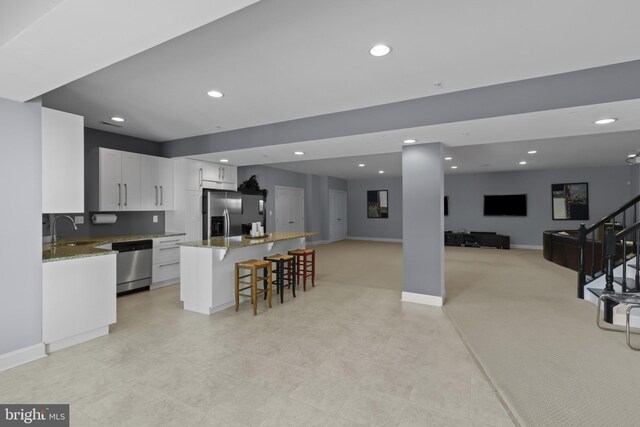 17621 Auburn Village Dr, Sandy Spring, MD 20860 - kitchen featuring appliances with stainless steel finishes, a sink, a breakfast bar, open floor plan, and white cabinetry