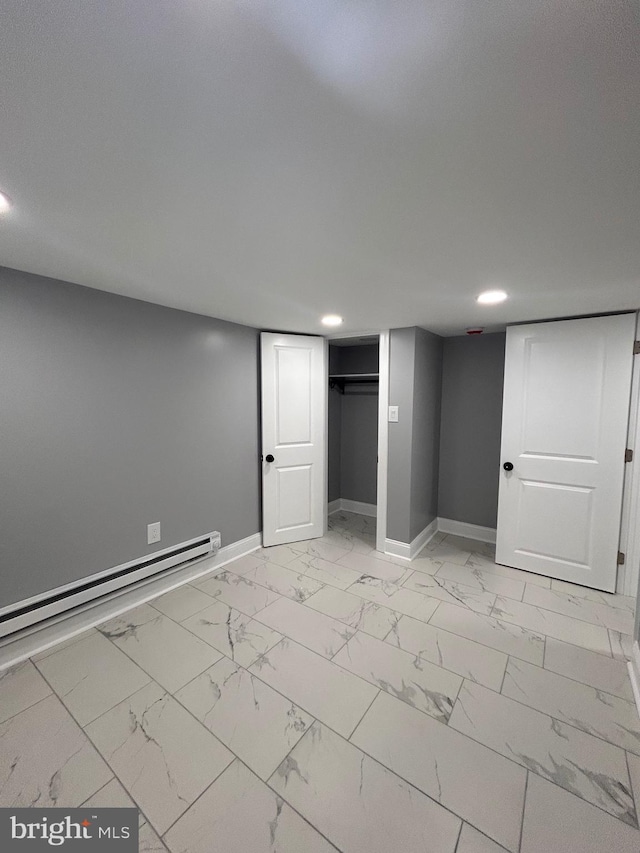 finished basement with baseboard heating, baseboards, recessed lighting, and light marble finish floors