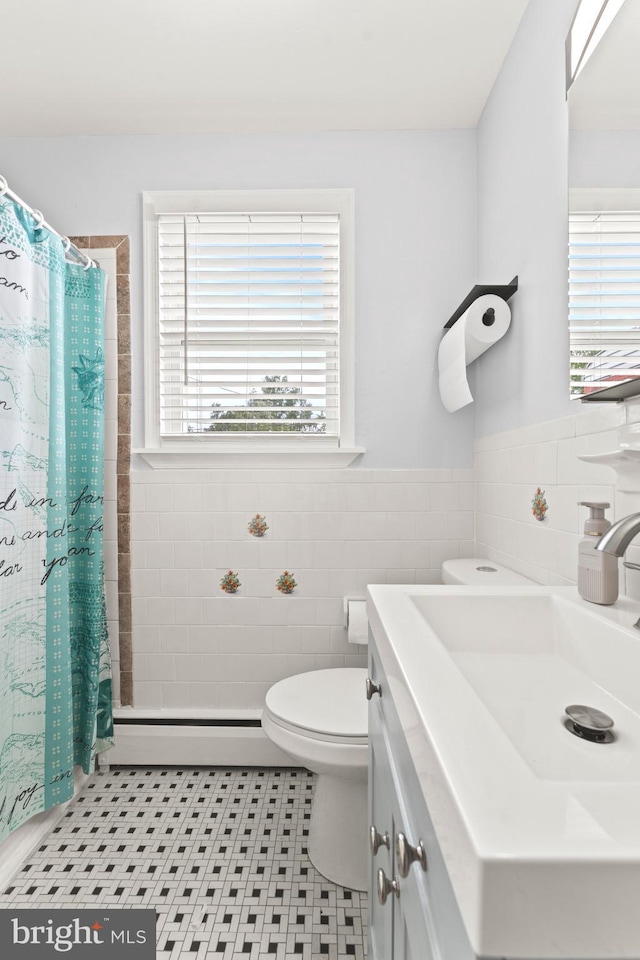 5911 Cecil Ave, Baltimore, MD 21207 - full bath featuring tile walls, baseboard heating, tile patterned floors, toilet, and vanity