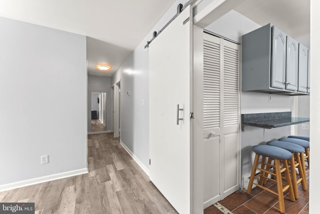 5911 Cecil Ave, Baltimore, MD 21207 - hallway with wood finished floors, a barn door, and baseboards
