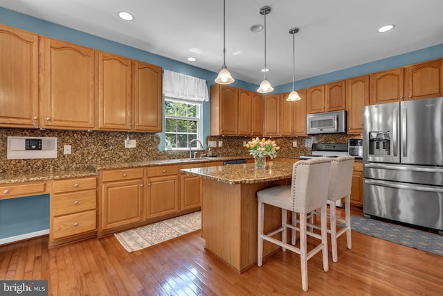 8139 Showcase Ct, Pasadena, MD 21122 - kitchen featuring stainless steel appliances, light wood-type flooring, dark stone counters, a kitchen breakfast bar, and recessed lighting