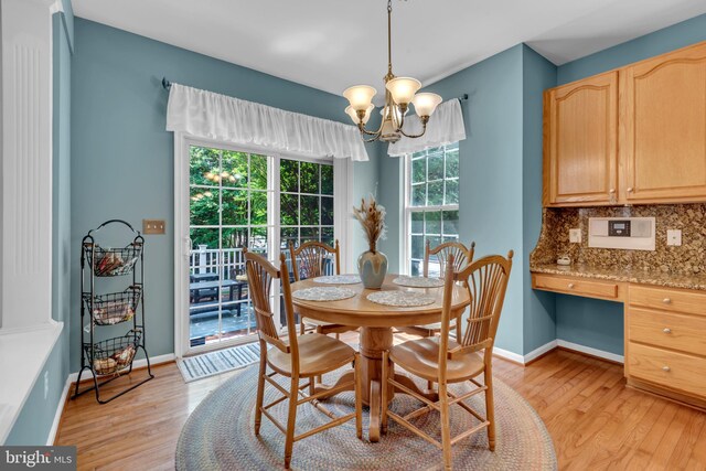 8139 Showcase Ct, Pasadena, MD 21122 - dining space featuring light wood finished floors, a chandelier, and baseboards