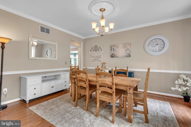 8139 Showcase Ct, Pasadena, MD 21122 - dining area with a chandelier, crown molding, wood finished floors, and baseboards