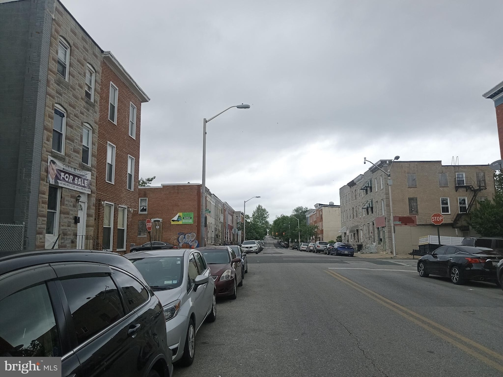 view of asphalt street with street lighting and traffic signs