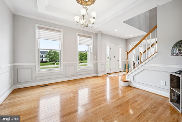 301 Nottingham Ln, Queenstown, MD 21658 - entrance foyer featuring a chandelier, crown molding, stairway, light wood-type flooring, and a wainscoted wall