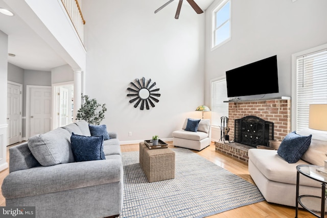 301 Nottingham Ln, Queenstown, MD 21658 - living area featuring ceiling fan, wood finished floors, a towering ceiling, and a brick fireplace