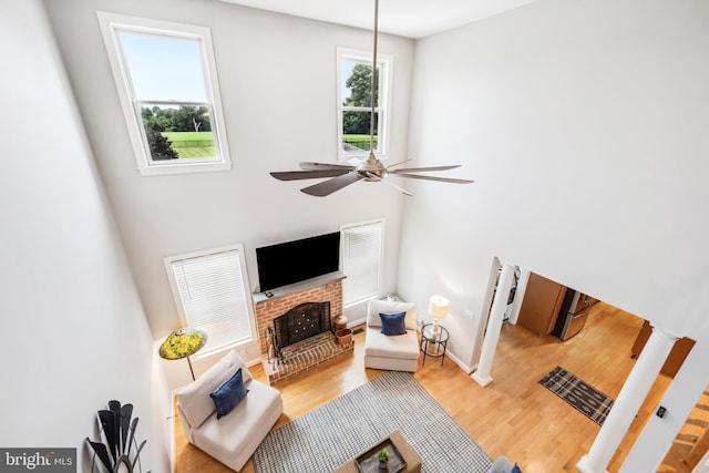 301 Nottingham Ln, Queenstown, MD 21658 - living room featuring light wood-type flooring, ceiling fan, and a brick fireplace
